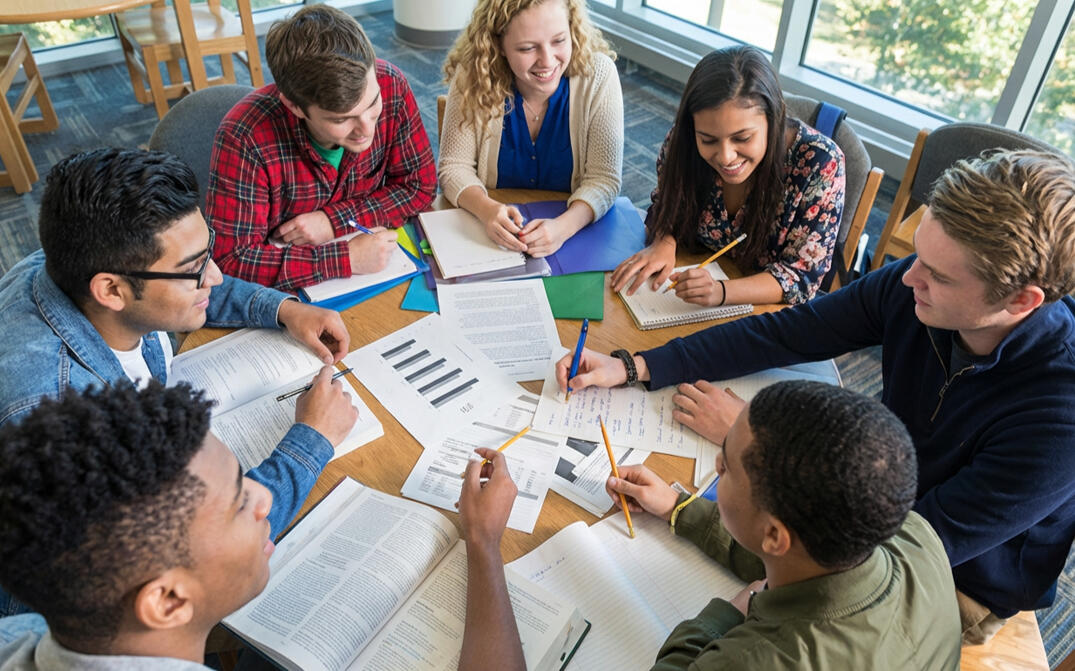person's hands holding a smart phone at a desk, with Facebook social media site login window